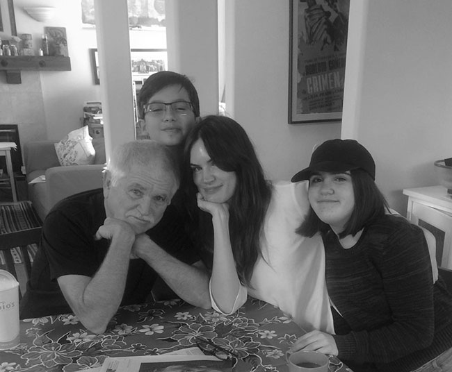 A photograph of Mike Davis seated at a table surrounded by his children.