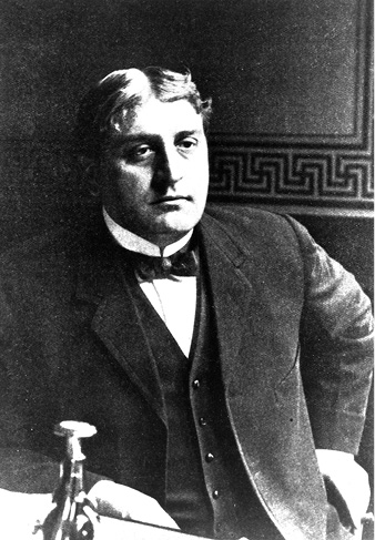 A head shot of a middle aged white male wearing a suit.