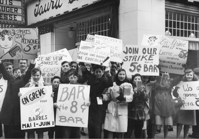A photograph of a group of children holding placards and protesting the rise in price of candy bars.